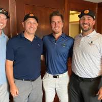 Four Alumni smiling at camera